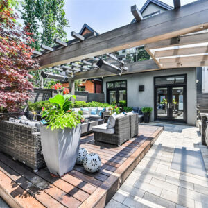 modern pergola spans full width of this city outdoor living back yard!